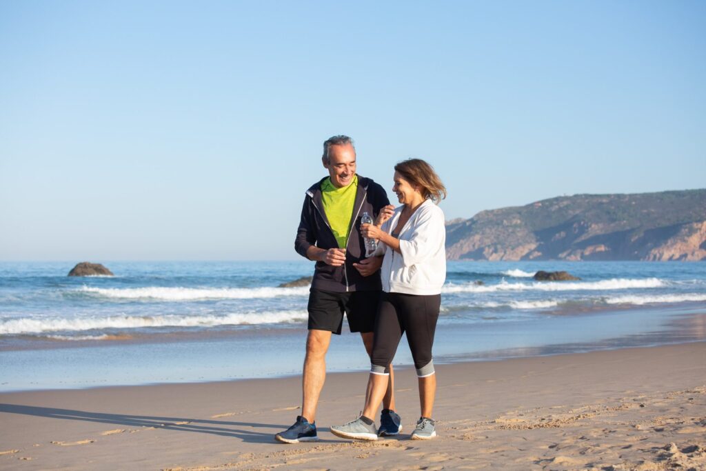 Active couple walking together on the beach