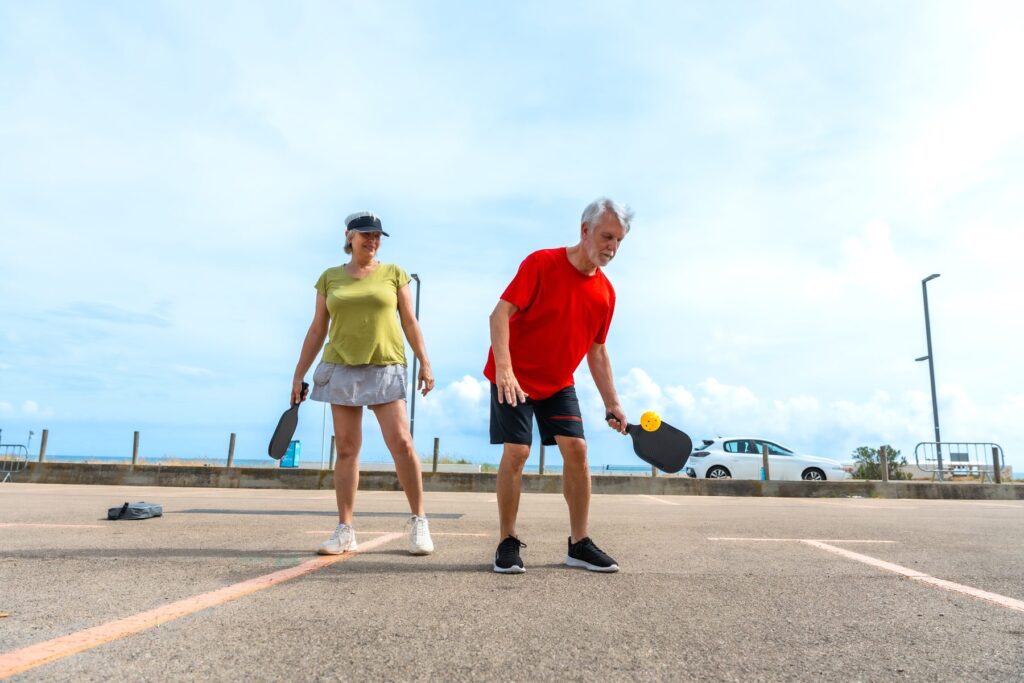 Active couple playing pickleball near the ocean